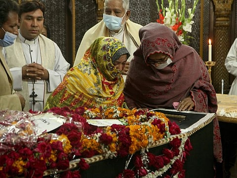 Family members look last glimpse of Christian priest Father William Siraj, 75, who was killed by unknown gunmen, during a funeral service at the All-Saints Church, in Peshawar on January 31, 2022.