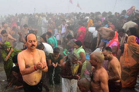 Hindu devotees take a holy dip at the Sangam, the confluence of the rivers Ganges and Yamuna and mythical Saraswati, on the auspicious bathing day of 'Mauni Amavasya' during the annual Magh Mela festival in Allahabad, on February 1, 2022.