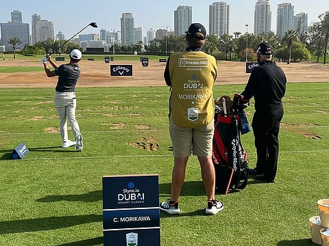 Eagle Eye: Peter Cowen (right, in black) keeps and eye on his famous ward Collin Morikawa at the Emirates Golf Club at the end of the Slync.io Dubai Desert Classic week.