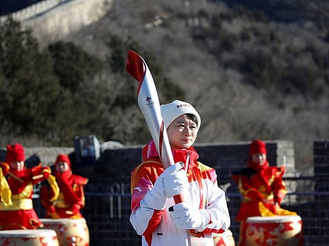 Chinese taekwondo Olympics medalist, Wu Jingyu, holding the Olympic torch before taking part in the Torch Relay at the Badaling section of the Great Wall in Yanqing district on Thursday.
