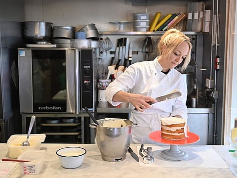 Baker Claire Ptak prepares a coconut pudding cake during an interview with AFP at her Violet Bakery in east London on January 27, 2022. Amateur British cooks are battling to create the best Platinum Jubilee pudding to mark 70 years of Queen Elizabeth II’s reign.