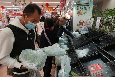 Customers wearing face masks shop at a market, following the outbreak of the coronavirus disease (COVID-19), at Sha Tin district, in Hong Kong, China, February 7, 2022.