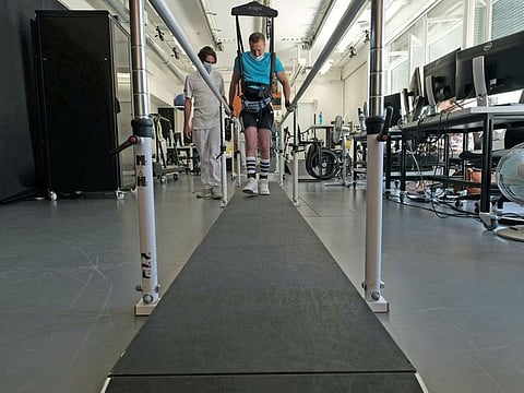 A 42-year-old patient performs training on a weight-supporting robot at Lausanne University Hospital after having received a spinal cord implant within the STIMO Bridge research, in this undated handout photo taken in Lausanne, Switzerland.