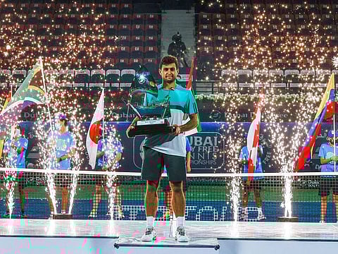 Aslan Karatsev holds the trophy after winning the Dubai Tennis Championships title.