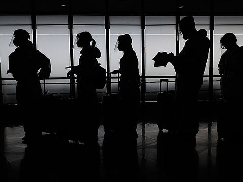 Foreign passengers wearing protective suits prepare for their flight to China at Manila's International Airport, Philippines.