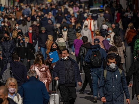 People walk along a street in downtown Madrid, on February 10, 2022.