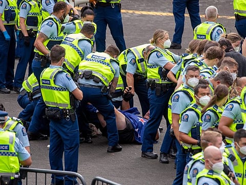 Police arrest people protesting against coronavirus mandates at Parliament in Wellington, New Zealand, Thursday, Feb. 10, 2022.