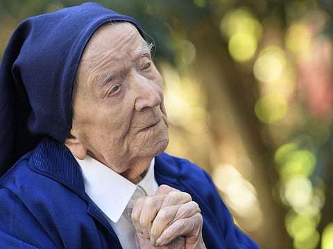 This file photo taken on February 10, 2021 shows Sister Andre praying in a wheelchair, on the eve of her 117th birthday in an EHPAD (Housing Establishment for Dependant Elderly People) in Toulon.