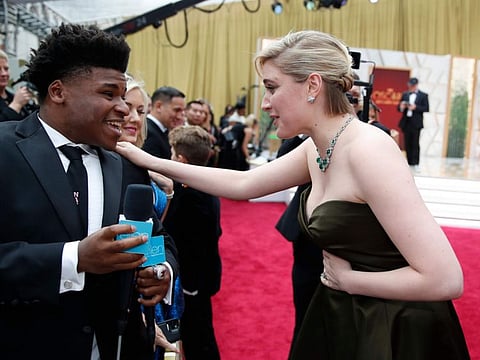 Greta Gerwig, right, talks to Jerry Harris on the red carpet at the Oscars at the Dolby Theatre in Los Angeles, Feb. 9, 2020.