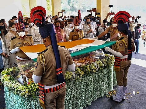 Soldiers place the national flag on the casket containing the body of Indian industrialist Rahul Bajaj during his last rites ceremony at the company campus in Akurdi Pimpri Chinchwad, in India's Maharashtra state on February 13, 2022, a day after his death.