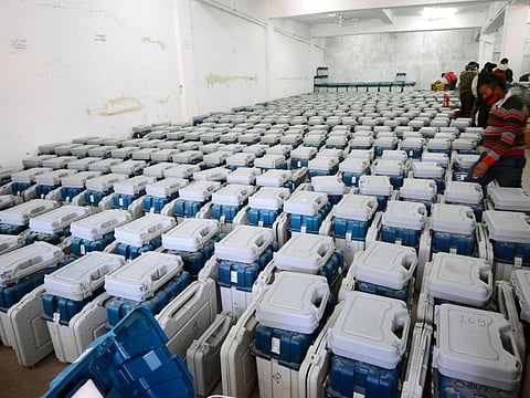 A polling official checks the Electronic Voting Machine (EVMs) stored in a room for the second phase of Uttar Pradesh Assembly elections, at Ramabai Ambedkar Rally Ground, in Lucknow on Saturday.
