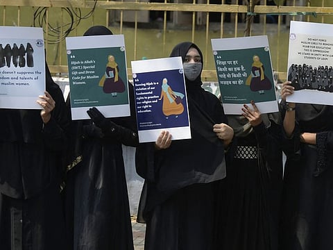 Members from the Muslim Women Association hold placards as they stand along a roadside during a silent protest after few Karnataka's educational institutes denied entry to students wearing hijabs, in Hyderabad on February 15, 2022.