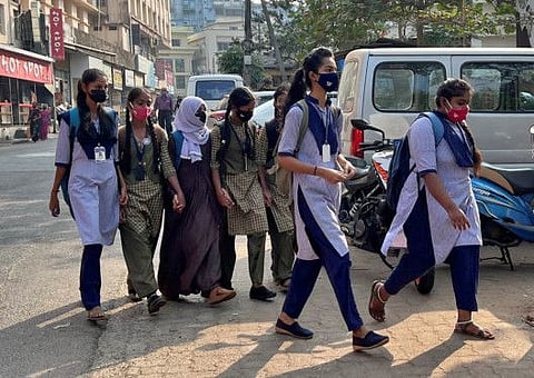 A Hijab wearing schoolgirl holds hands of her classmates as she arrives to attend the classes at a government girls school after the recent hijab ban, in Udupi town in the southern state of Karnataka, India, February 16, 2022.