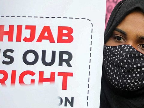 A Muslim student holds a placard during a protest by the Muslim Students Federation (MSF) against the recent hijab ban in  Karnataka’s schools, in New Delhi, India, February 8, 2022.