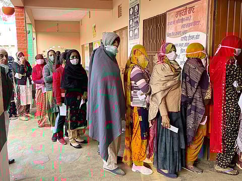 Voters stand in a queue to cast their votes for the Punjab Assembly elections, at a polling booth, Government College for Girls, in Patiala on Sunday.