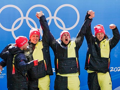 Francesco Friedrich, Thorsten Margis, Candy Bauer and Alexander Schueller, of Germany, celebrate winning the gold medal in the 4-man at the 2022 Winter Olympics in the Yanqing district of Beijing.