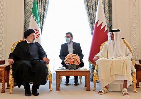 A handout picture provided by the Iranian presidency shows Qatar's Emir Sheikh Tamim bin Hamad Al Thani meeting with Iranian President Ebrahim Raisi upon his arrival in Doha, on February 21, 2022.