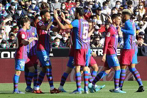 Barcelona's Pierre-Emerick Aubameyang celebrates with team mates after scoring the opening goal during the La Liga match against Valencia at the Mestalla stadium in Valencia, Spain.