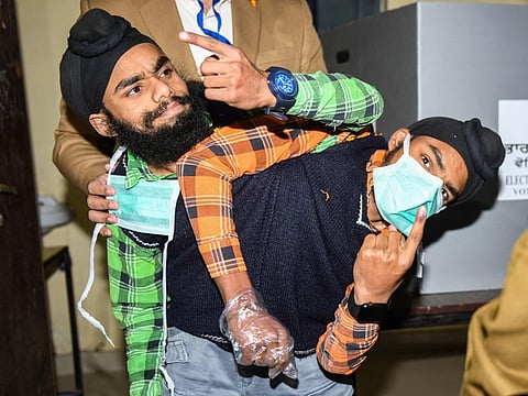 Conjoined twins show the inked finger after casting their ballot at a polling station in a village on the outskirts of Amritsar on February 20, 2022, during the Punjab state assembly elections.