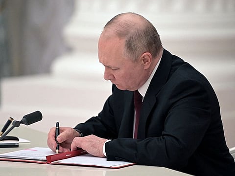 Russian President Vladimir Putin signs documents, including a decree recognising two Russian-backed breakaway regions in eastern Ukraine as independent entities, during a ceremony in Moscow, Russia, in this picture released February 21, 2022.