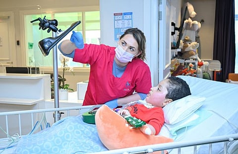 A therapist works with Ali, 6, and helps him communicate with visitors to Salma Children's Rehabilitation Hospital in Abu Dhabi. Ali has spinal muscular atrophy, a progressive neuromuscular disease.