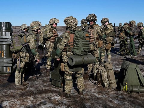 This handout picture released on February 19 by the press service of the General Staff of the Ukrainian Armed Forces in an unknown location shows servicemen prior to shooting with a Swedish-British portable anti-tank guided missile NLAW that was transferred to the units as part of Britain's military-technical assistance, as they take part in exercises.