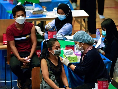 A health worker administers a dose of the AstraZeneca COVID-19 vaccine to a woman in Bangkok, Thailand, on February 23, 2022.