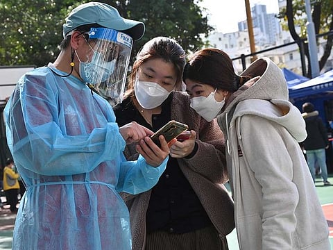 People check in at a COVID-19 testing centre in Hong Kong on February 25, 2022, as yet another record high number of new infections were recorded in the city.
