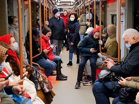 People ride a subway carriage as some of them read on their smartphones in Moscow, Russia.