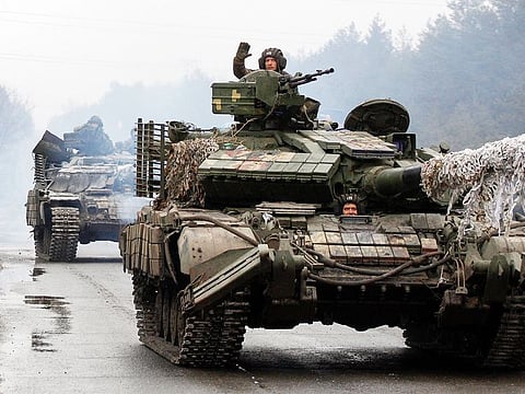 Ukrainian servicemen ride on tanks towards the front line with Russian forces in the Lugansk region of Ukraine on February 25, 2022.