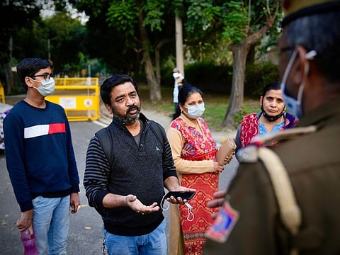 Family of an Indian student studying in Ukraine pleads in front of a police officer to allow them to see officials at Russian embassy in New Delhi, India, Friday, Feb. 25, 2022.
