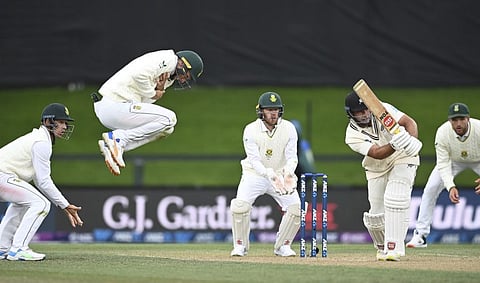 Colin de Grandhomme bats for New Zealand as South Africa's Rassie van der Dussen leaps in the air during play on day two of the second cricket Test between South Africa and New Zealand at Hagley Oval in Christchurch, New Zealand.