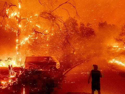 Bruce McDougal watches embers fly over his property as the Bond Fire burns through the Silverado community in Orange County, Calif., on Dec. 3, 2020. The United Nations on Monday, Feb. 28, 2022, released a new report on climate change.