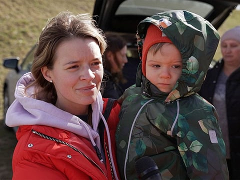 Svetlana, 28, a Ukrainian woman from Kyiv, stands with her son Semyon as they arrive at the Hungarian border village of Tiszabecs, Hungary March 1, 2022 in this still image taken from a video.