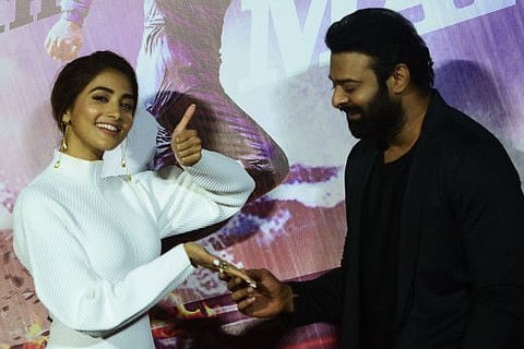 South Indian actor Prabhas (right) and Bollywood actress Pooja Hegde pose for a picture during the trailer launch of their upcoming Indian period romantic drama film 'Radhe Shyam' in Mumbai on March 2, 2022.
