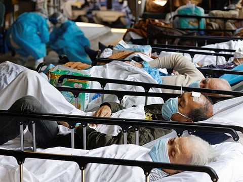 Patients rest at a makeshift treatment area outside a hospital in Hong Kong, on March 2, 2022.