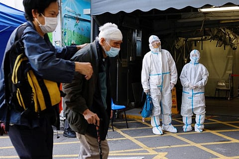 A patient and her relative wearing personal protective equipment (PPE) wait outside the Accident and Emergency (A&E) department, following the coronavirus disease (COVID-19) outbreak, in Hong Kong, China March 4, 2022.