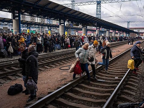 People crowd as they try to get on a train to Lviv at the Kyiv station, Ukraine, Friday, March 4. 2022.