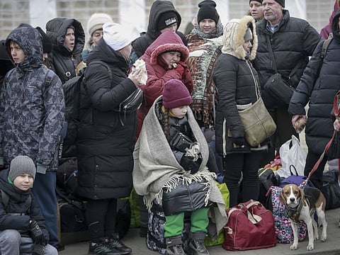 People, fleeing Ukraine, wait for a bus which will take them at the train station in Przemysl, in the border crossing Medyka, Poland, Friday, March 4, 2022.