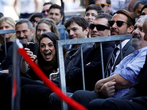 Mila Kunis and Ashton Kutcher sit in the audience during the ceremony for the unveiling of Zoe Saldana's star on the Hollywood Walk of Fame in Los Angeles, California, U.S. May 3, 2018.