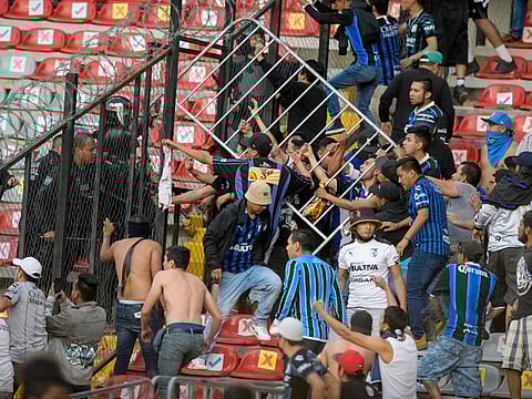 Fans clash during a Mexican soccer league match between the host Queretaro and Atlas from Guadalajara, at the Corregidora stadium, in Queretaro, Mexico. Multiple people were injured during the brawl, including two critically.