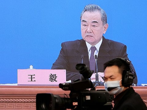 Chinese State Councilor and Foreign Minister Wang Yi is seen on a screen as he attends a news conference via video link on the sidelines of the National People's Congress (NPC), in Beijing, China March 7, 2022.