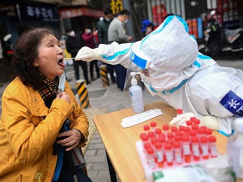 This photo taken on March 6, 2022 shows a resident undergoing a nucleic acid test for the COVID-19 coronavirus in Wuhan in China's central Hubei province.