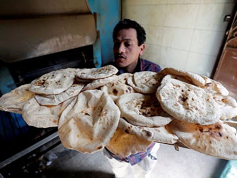 A baker carries bread in Al Kalubia governorate, northeast of Cairo, March 1, 2022.