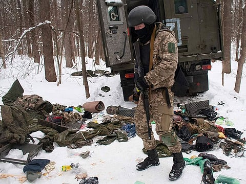 A volunteer of the Ukrainian Territorial Defense Forces inspects a damaged military vehicle in the outskirts Kharkiv, Ukraine's second-largest city,.