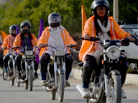 Participants of Women on Wheels (WOW) ride their motorbikes to mark International Womens Day in Karachi.