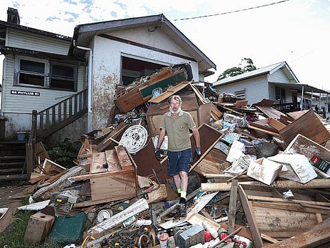 Ken Bridge stands amongst his flood damaged furniture outside his home in Lismore, on March 9, 2022. Australia’s prime minister Scott Morrison on Wednesday declared a national emergency following floods across large swathes of the east coast that have claimed 21 lives.