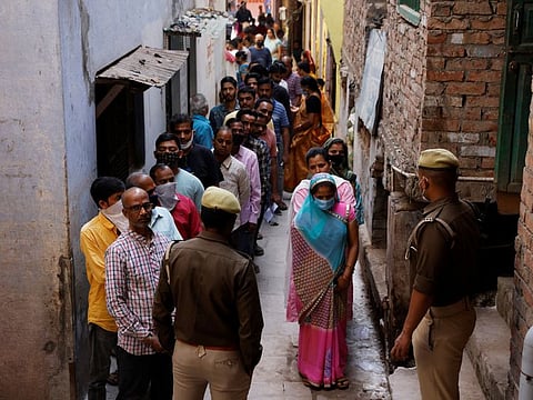 People stand in a queue to cast their votes at a polling station during the last phase of state assembly election in Varanasi in the northern state of Uttar Pradesh, on March 7, 2022.