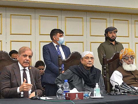 Pakistani opposition leaders Shahbaz Sharif (left), leader of the opposition in the National Assembly, speaks during a press conference next to Asif Ali Zardari (centre), former President and leader of Pakistan Peoples Party (PPP), and Fazlur Rehman, head of Jamiat Ulema-e-Islam party, after submitting the no-trust motion against Prime Minister Imran Khan on March 8, 2022.