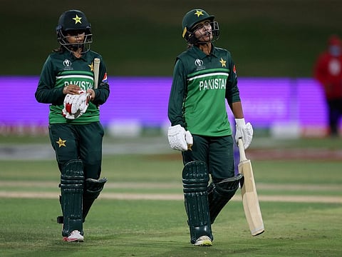 Pakistan's Nashra Sandhu (right) and Ghulam Fatima walk off the field after their loss during the 2022 Women's Cricket World Cup match against South Africa at Bay Oval in Tauranga.